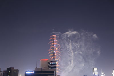 Low angle view of illuminated buildings against sky at night