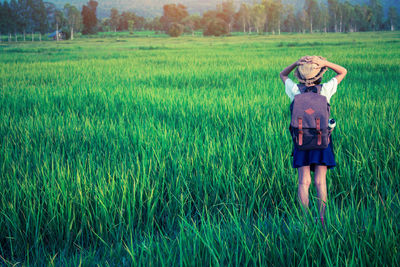 Rear view of woman standing in field