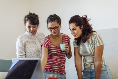 Content diverse women surfing laptop creating new startup