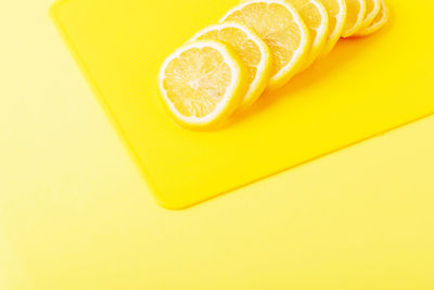 High angle view of yellow slice on orange background