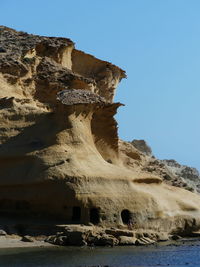 Scenic view of rock formations against clear blue sky