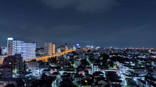 High angle view of illuminated buildings against sky at night