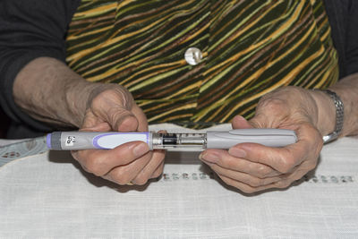 Close-up of man holding camera on table