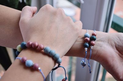 Cropped hands of woman wearing bracelets at home