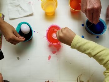 Cropped hands coloring easter eggs