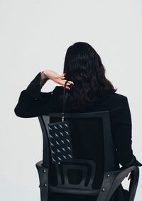 Woman with arms raised standing against white background