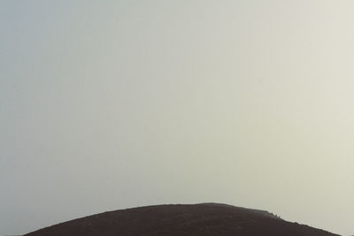 Low angle view of silhouette mountain against clear sky