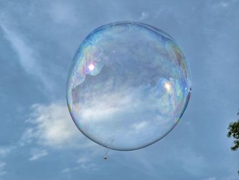 Low angle view of bubbles against blue sky