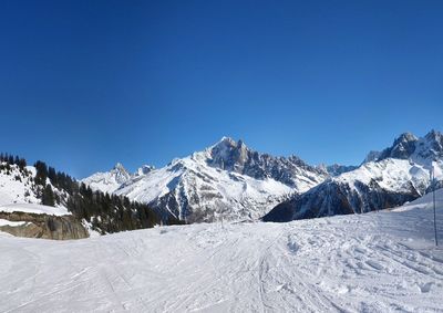 Snowcapped mountains against clear blue sky