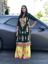 Portrait of woman standing on land by car