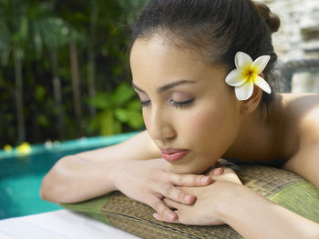 Close-up of young woman with eyes closed against trees