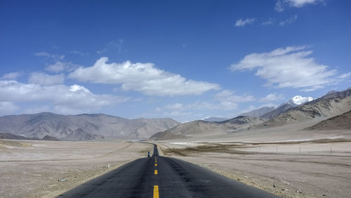 A flat new unmanned road leads to the snowy mountains ahead