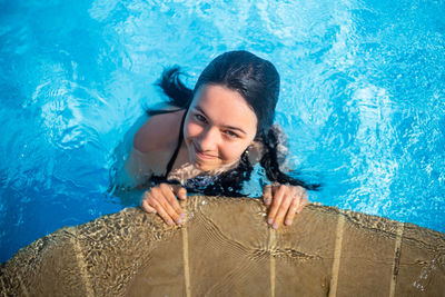 Portrait of young woman swimming in pool