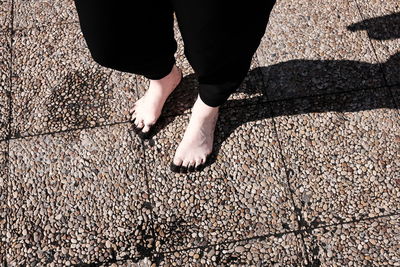 Low section of woman standing on tiled floor