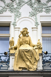 Low angle view of statue against historic building