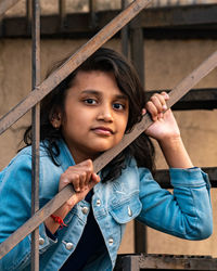 Low angle view of young woman sitting on railing