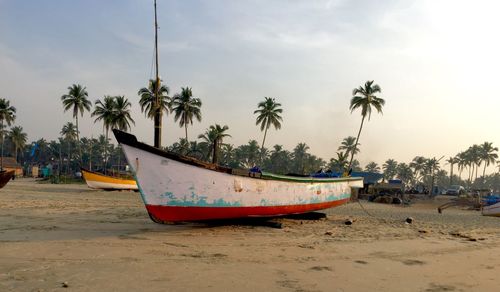 Boat moored at beach against sky