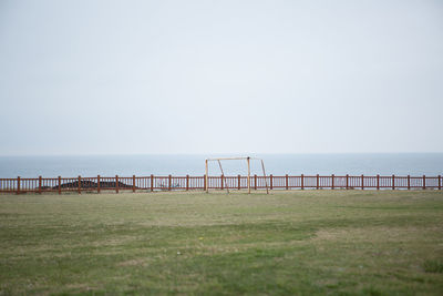 Goalpost set against the sea and clear skies.