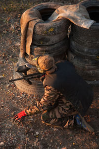 Army soldier hiding behind stack of tire