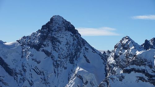 Scenic view of snowcapped mountains against blue sky