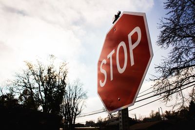 Low angle view of road sign against sky