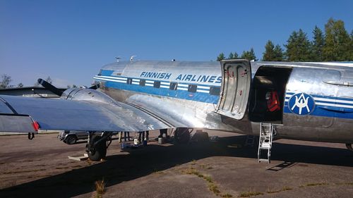 Airplane on airport runway against clear blue sky