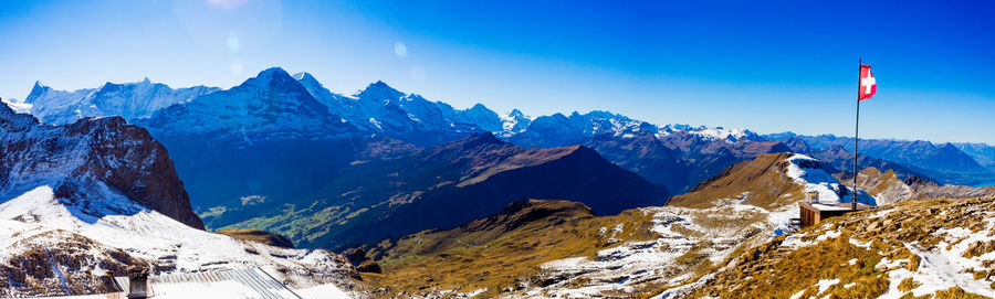 Scenic view of snowcapped mountains against blue sky