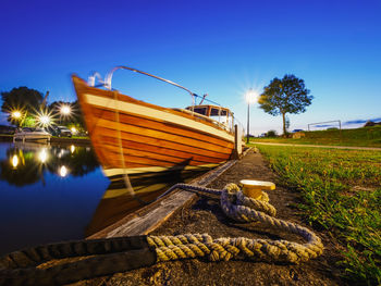 Wide view on metal bollard or hook on a quay where moored wooden motorboat, calm dusk view