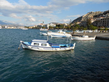 Nautical vessel moored on sea against buildings in city