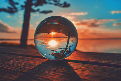 Close-up of illuminated lamp on table against sky during sunset