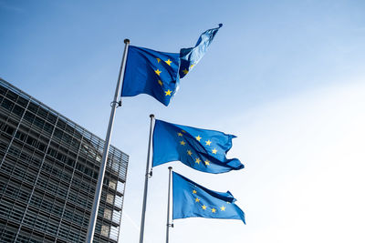 Low angle view of flag flags against blue sky