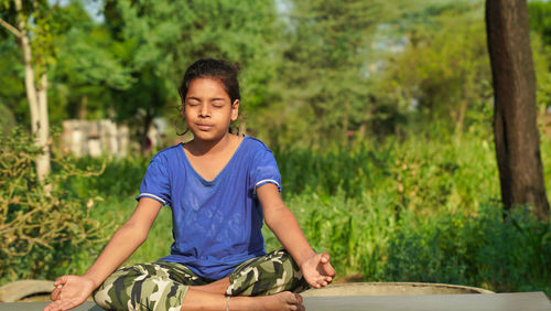 Indian child doing exercise on platform outdoors. healthy lifestyle. yoga girl.