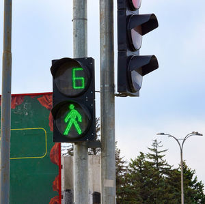 Traffic light with green light on a pole, count the seconds until the end of the pedestrian traffic