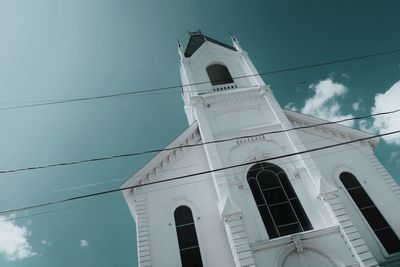 Low angle view of clock tower amidst buildings against sky