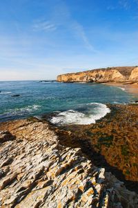 Scenic view of sea against sky with rocky coastline