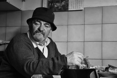 Man smoking cigarette while sitting at table