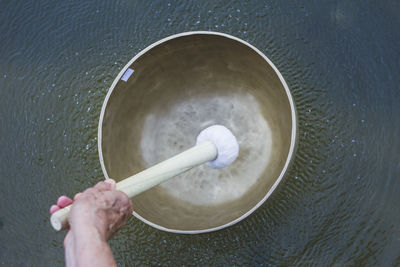 Vibrating tibetan singing bowl is floating on water 