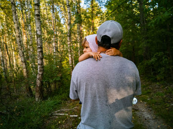 Rear view of man and woman standing in forest