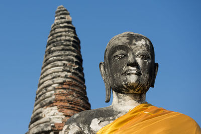 Low angle view of buddha statue at wat mahathat against clear sky