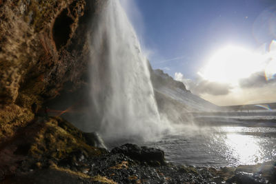 Scenic view of waterfall against sky