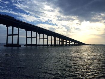 Bridge over sea against sky during sunset