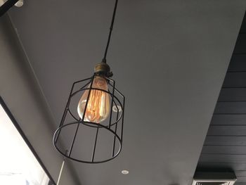 Low angle view of illuminated pendant light hanging from ceiling