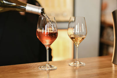 A bartender pours rose and white french wine