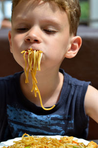 Close-up of boy eating spaghetti at restaurant