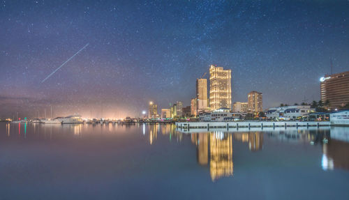 Reflection of illuminated buildings in city at night