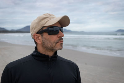 Portrait of young man wearing hat at beach