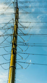 Low angle view of electricity pylon against sky