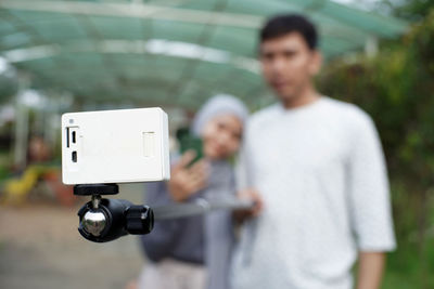 Midsection of man holding camera