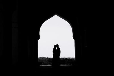 Rear view of silhouette woman standing in building