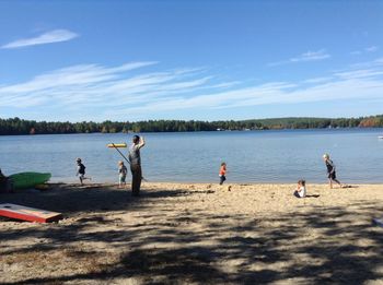 Man and playful children at lakeshore